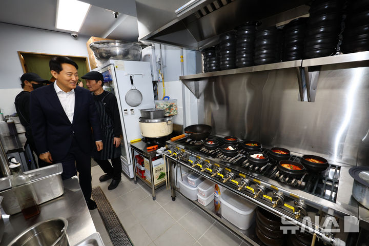 [서울=뉴시스] 박주성 기자 = 오세훈 서울시장이 16일 서울 용산구에 '희망의 인문학' 수료생들이 직접 운영하는 동행스토어 1호점 집밥 음식점 '정담(情談)' 을 찾아 주방을 둘러보고 있다. 희망의 인문학이란 인문학 수업을 통해 노숙인 등이 자존감을 회복하고 지역 사회에서 자립할 수 있도록 돕는 서울시 사업이다.'정이 담긴 진심 어린 이야기'라는 의미인 정담(情談)은 참여자들이 재기를 위해서 노력하고 진심으로 음식을 만든다는 의지를 담았다. 희망의 인문학 수료생 중 조리사 등 경험이 있는 5명이 직접 운영한다. 2025.12.16. park7691@newsis.com