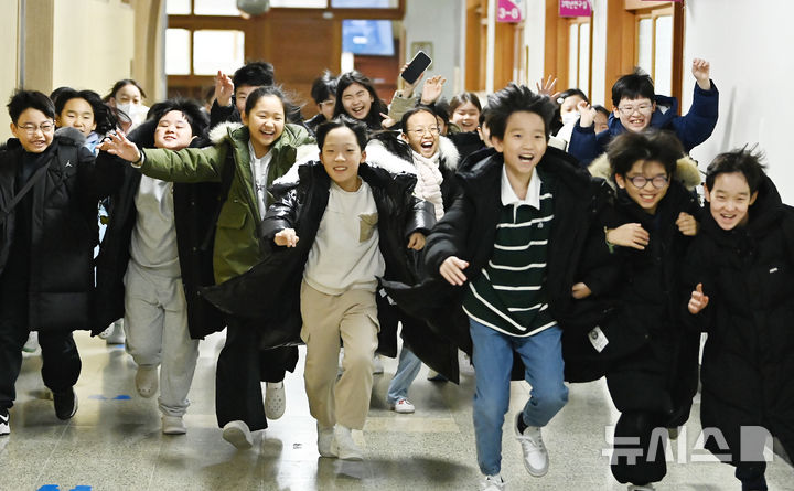 [수원=뉴시스] 김종택 기자 = 겨울방학식이 열린 16일 경기 수원시 영통구 잠원초등학교에서 4학년8반 학생들이 방학안내문을 들어보이고 있다. 2025.12.16. jtk@newsis.com