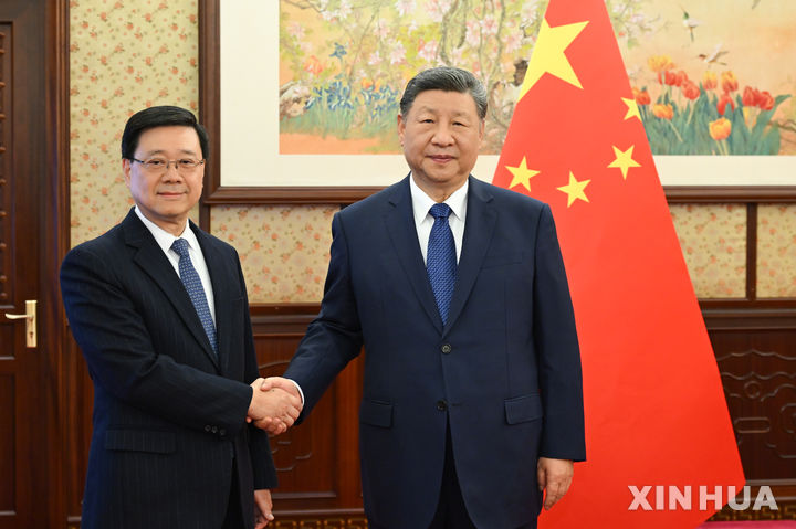 [베이징=신화/뉴시스] 시진핑 중국 국가주석이 16일 중국 베이징을 방문한 존 리 홍콩특별행정구 행정장관과 만나 악수하고 있다. 2025.12.17