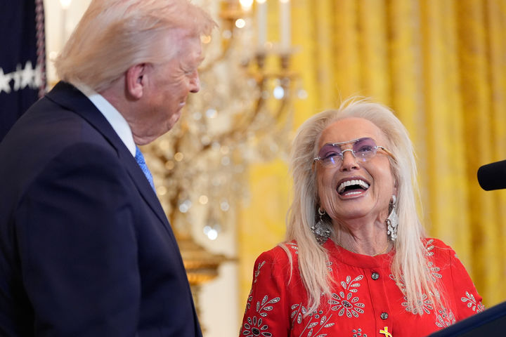 [워싱턴=AP/뉴시스]도널드 트럼프 미 대통령이 16일(현지시각) 백악관에서 열린 유대 명절 하누카 축하파티에서 자신의 3선 출마를 권유하는 지지자 미리엄 애델슨과 대화하며 웃고 있다. 2025.12.18. 