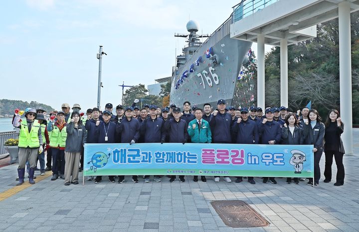 [창원=뉴시스] 강경국 기자 = 정현섭 경남 창원시 진해구청장이 해군이 함께하는 환경정화 활동인 '해군과 함께하는 플로깅 in 우도' 참가자들과 함께 기념촬영을 하고 있다. (사진=창원시청 제공). 2025.12.17. photo@newsis.com *재판매 및 DB 금지