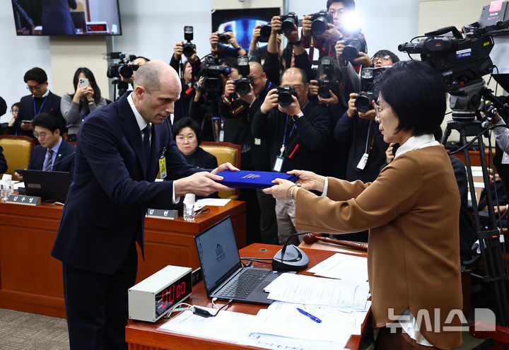 [서울=뉴시스] 김명년 기자 = 해롤드 로저스 쿠팡 임시 대표가 17일 오전 서울 여의도 국회 과학기술정보방송통신위원회 전체회의에서 열린 쿠팡 침해사고 관련 청문회에서 최민희 위원장에게 선서문을 전달하고 있다. 2025.12.17. kmn@newsis.com