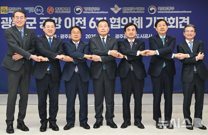 [광주=뉴시스] 이영주 기자 = 17일 오전 광주 서구 광주도시공사에서 열린 광주군공항이전 6자협의체회의에 참석한 내빈들이 손을 맞잡고 기념사진을 촬영하고 있다. 강희업 국토교통부 제2차관(왼쪽부터), 김영록 전남도지사, 강기정 광주시장, 김산 전남 무안군수, 안규백 국방부장관, 구윤철 기획재정부장관, 안규백 국방부장관, 김용범 대통령비서실 정책실장. 2025.12.17. leeyj2578@newsis.com