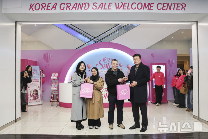 [서울=뉴시스] 권창회 기자 = 이부진 한국방문의해위원장과 김대현 문화체육관광부 2차관이 17일 오전 서울 중구 눈스퀘어에 위치한 코리아그랜드세일 웰컴센터에서 외국인 관광객과 기념촬영을 하고 있다. (공동취재) 2025.12.17. photo@newsis.com