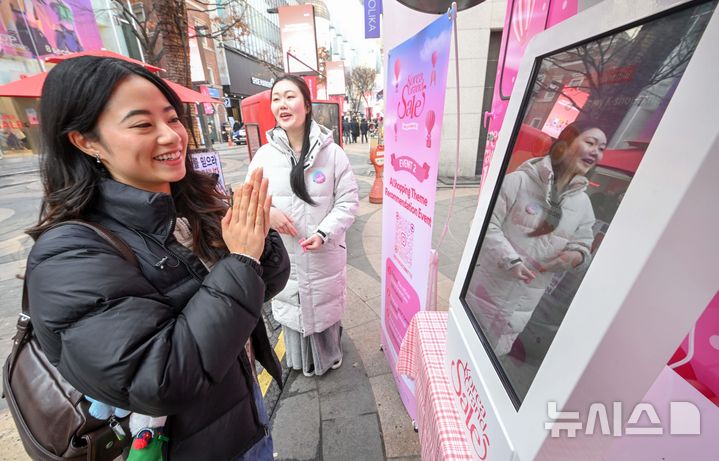 [서울=뉴시스] 권창회 기자 = 코리아그랜드세일이 시작된 17일 오전 서울 중구 명동거리 일대에서 관광객이 홍보부스를 체험하고 있다. 문체부와 한국방문의해위원회는 외국인의 방한 관광과 소비를 촉진하기 위해 쇼핑관광축제 '2026 코리아그랜드세일'을 내년 2월 22일까지 개최한다. (공동취재) 2025.12.17. photo@newsis.com