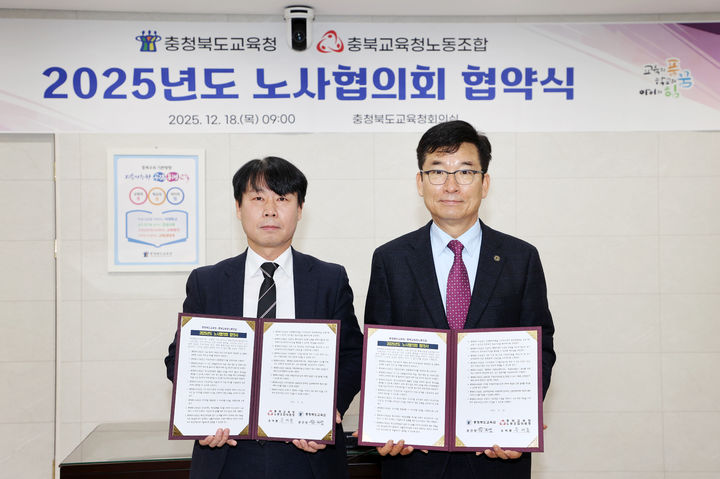 [청주=뉴시스] 18일 윤건영 충북교육감(오른쪽)과 유여종 충북교육청노조 위원장이 교육감실에서 '2025년도 노사협의회 합의안'에 서명하고 기념 촬영을 하고 있다. (사진=충북교육청 제공) 2025.12.18. photo@newsis.com&nbsp; *재판매 및 DB 금지