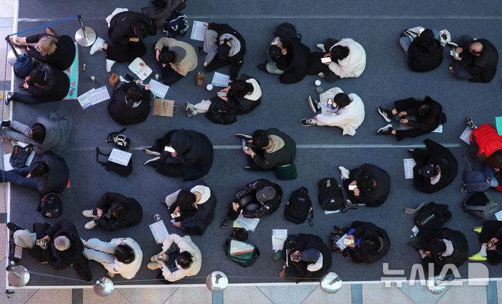 [서울=뉴시스] 홍효식 기자 = 18일 서울 강남구 코엑스에서 열린 2026학년도 정시 대학입학정보박람회를 찾은 학부모와 입시생들이 입장하기 위해 앉아 기다리고 있다. 2025.12.18. yesphoto@newsis.com