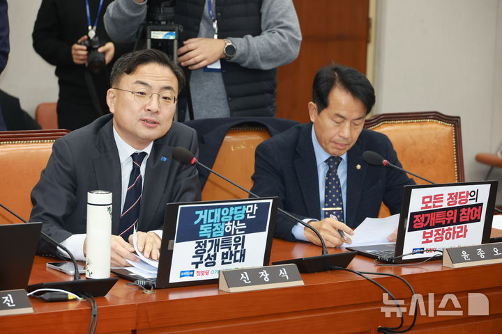 [서울=뉴시스] 고승민 기자 = 신장식 조국혁신당 의원과 윤종오 진보당 원내대표가 18일 서울 여의도 국회에서 열린 운영위원회 전체회의에서 노트북에 피켓을 부착하고 있다. 2025.12.18. kkssmm99@newsis.com