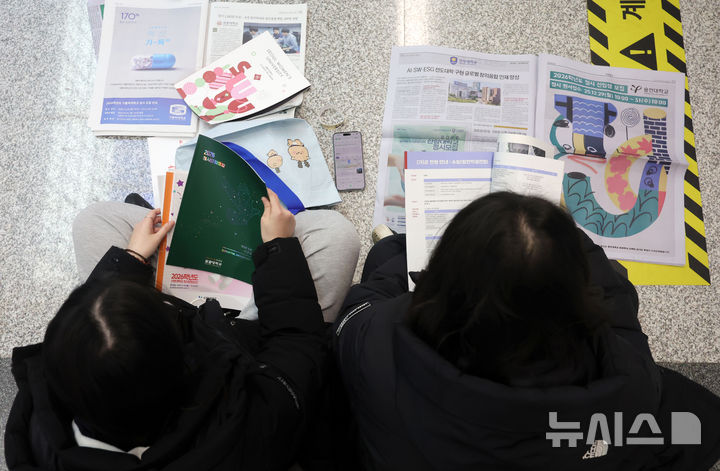 [서울=뉴시스] 홍효식 기자 = 18일 서울 강남구 코엑스에서 열린 2026학년도 정시 대학입학정보박람회를 찾은 입시생들이 자료를 살펴보고 있다. 2025.12.18. yesphoto@newsis.com