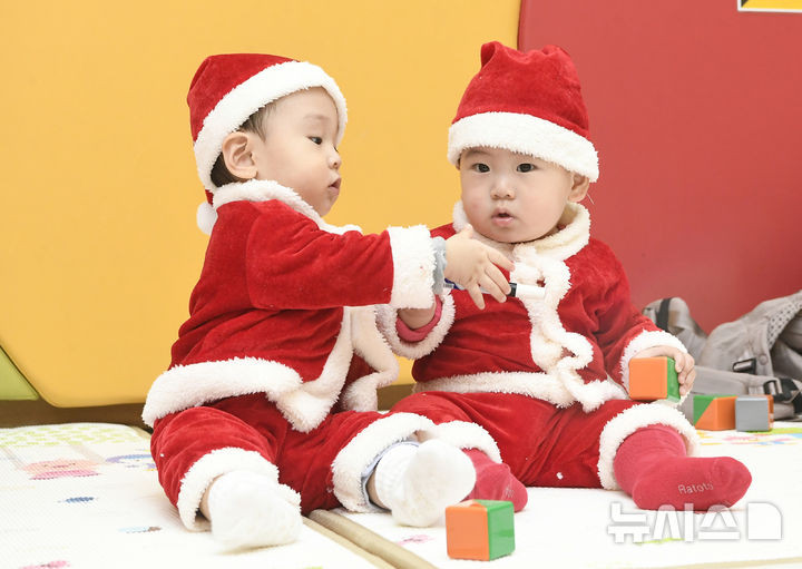 [경기광주=뉴시스] 김종택 기자 = 성탄절을 일주일 앞둔 18일 경기 광주시 능평도서관에서 한토이 어린이서점이 주최한 '꼬꼬마 아기들 모임-산타와 함께하는 첫 만남, 책! 행복한 우리 아기를 위한 시간' 프로그램에 참여한 아기 산타들이 교육 체험형 놀이를 하며 즐거운 시간을 보내고 있다. (공동취재) 2025.12.18. photo@newsis.com