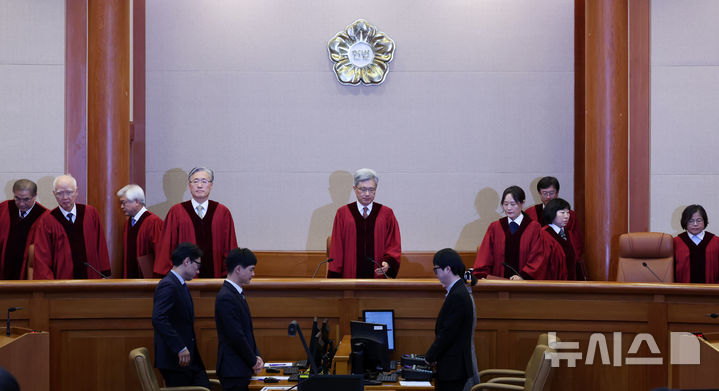 [서울=뉴시스] 조성우 기자 = 김상환(가운데) 헌법재판소장과 헌법재판관들이 18일 오후 서울 종로구 헌법재판소 대심판정에서 열린 조지호 경찰청장 탄핵심판 사건 선고기일에 입장하고 있다. 2025.12.18. xconfind@newsis.com