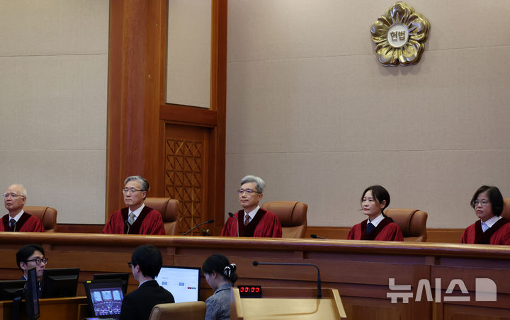 [서울=뉴시스] 조성우 기자 = 김상환(가운데) 헌법재판소장과 헌법재판관들이 18일 오후 서울 종로구 헌법재판소 대심판정에서 열린 조지호 경찰청장 탄핵심판 사건 선고기일에 자리하고 있다.헌법재판소는 조 청장의 탄핵심판에 대해 재판관 9명 전원일치 의견으로 파면 결정했다. 국회가 탄핵소추안을 가결한 지 371일만의 일이다. 2025.12.18. xconfind@newsis.com