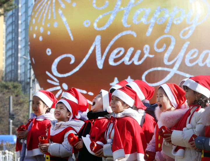[서울=뉴시스] 산타 복장을 차려입은 송파구청 어린이집 아이들이 18일 서울 송파구 석촌호수 더 스피어에서 크리스마스 캐럴을 부르고 있다. (사진=송파구 제공) 2025.12.18. photo@newsis.com *재판매 및 DB 금지