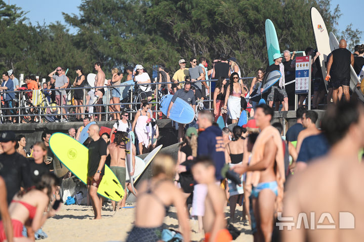 [시드니=AP/뉴시스] 19일(현지 시간) 호주 시드니 본다이비치 앞 바다에서 서퍼와 수영객들이 지난 14일 발생한 총격 희생자들을 추모하는 헌정 수영 행사에 참여하고 있다. 2025.12.19.