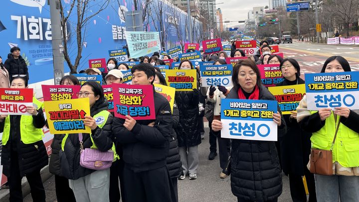 [수원=뉴시스] 19일 경기도교육청 남부청사 앞에서 열린 과천시 교육환경 정상화 요구 집회에서 학부모와 학생들이 '비어있는 일반고 1개교 중학교 전환' 등의 피켓을 들고 교육구조 개선을 촉구하고 있다.. (사진=과천시 학부모 대표단 제공) 2025.12.19. photo@newsis.com *재판매 및 DB 금지