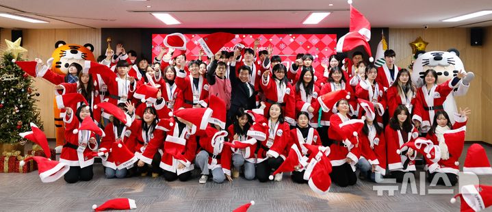 [서울=뉴시스]지난해 12월 출정식 후 산타모자를 던지는 봉사 참가자들.(제공=송파구)