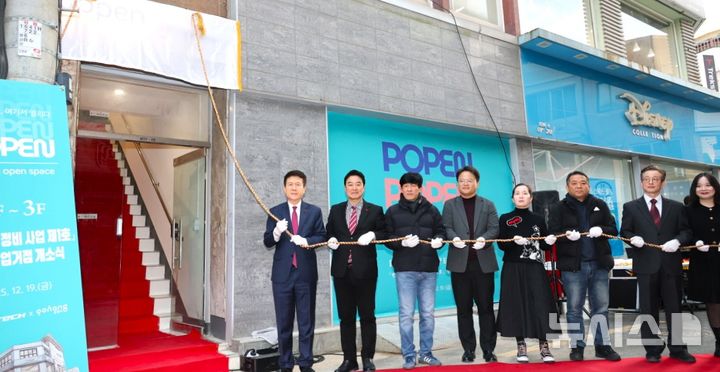 [포항=뉴시스] 송종욱 기자 = 19일 북구 상원동 중앙상가 실개천 거리에서 빈 건축물을 리모델링해 '청년 창업 거점 POPEN 개소식'에서 이강덕 시장과 청년 대표 등 참석자들이 현판식을 하고 있다. (사진=포항시 제공) 2025.12.19. photo@newsis.com 