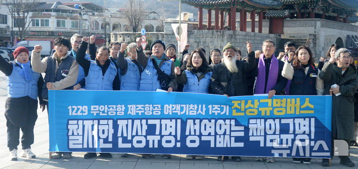[전주=뉴시스] 김얼 기자 = 12.29 무안공항 제주항공 여객기 참사 유가족 협의회를 비롯한 관계자들이 19일 전북 전주시 전주풍남문광장에서 '12.29 무안공항 제주항공 여객기 참사 1주기 "진실과 연대의 버스" 전국순회' 기자회견을 열고 구호를 외치고 있다. 2025.12.19. pmkeul@newsis.com