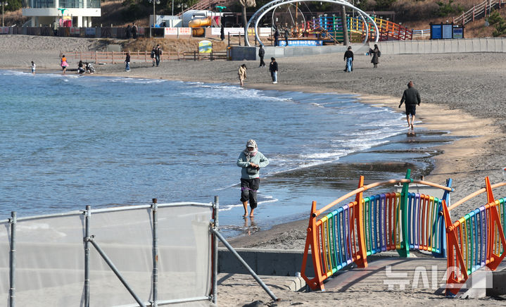 [제주=뉴시스] 우장호 기자 = 포근한 날씨를 보인 19일 오전 제주시 이호테우 해안도로에서 관광객들이 가벼운 반팔 차림으로 걸어가고 있다. 2025.12.19. woo1223@newsis.com