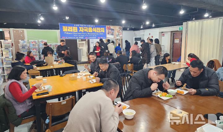 [창원=뉴시스]20일 오후 경남이주민센터 강당에서 열린 경남필리핀교민회 주최 'STX와 함께하는 자국음식잔치-말리가양 빠스코' 행사에 참석한 필리핀 이주민 등이 음식을 먹으며 즐거운 시간을 보내고 있다.(사진=경남이주민센터 제공) 2025.12.20. photo@newsis.com
