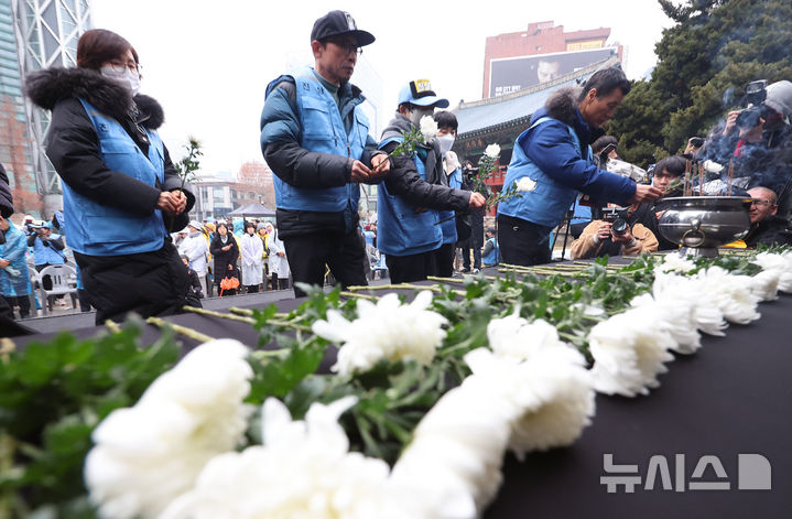 [서울=뉴시스] 조성우 기자 = 20일 오후 서울 종로구 보신각 앞에서 열린 12.29 무안공항 제주항공 여객기 참사 1주기 전국 시민 추모대회에서 여객기 참사 유가족들이 헌화하고 있다. 2025.12.20. xconfind@newsis.com