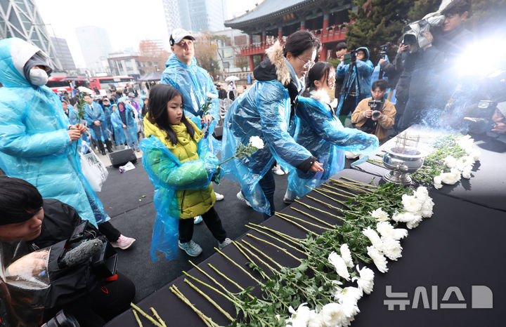 [서울=뉴시스] 조성우 기자 = 20일 오후 서울 종로구 보신각 앞에서 열린 12.29 무안공항 제주항공 여객기 참사 1주기 전국 시민 추모대회에서 여객기 참사 유가족들이 헌화하고 있다. 2025.12.20. xconfind@newsis.com