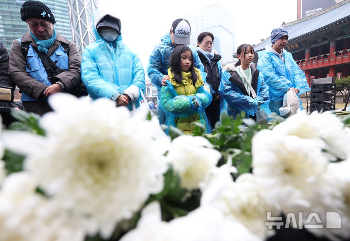 [서울=뉴시스] 조성우 기자 = 20일 오후 서울 종로구 보신각 앞에서 열린 12.29 무안공항 제주항공 여객기 참사 1주기 전국 시민 추모대회에서 여객기 참사 유가족들이 헌화하고 있다. 2025.12.20. xconfind@newsis.com