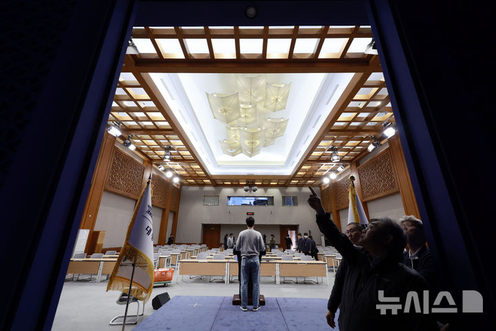 [서울=뉴시스] 최동준 기자 = 대통령실이 청와대 이전을 진행 중인 21일 청와대 춘추관에서 직원과 취재진이 브리핑룸 점검을 하고 있다. 2025.12.21. photocdj@newsis.com