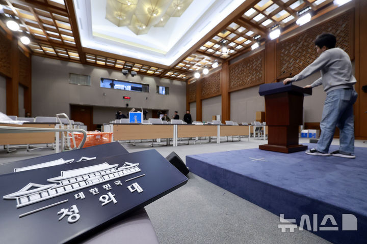 [서울=뉴시스] 최동준 기자 = 대통령실이 청와대 이전을 진행 중인 21일 청와대 춘추관에서 직원과 취재진이 브리핑룸 점검을 하고 있다. 2025.12.21. photocdj@newsis.com