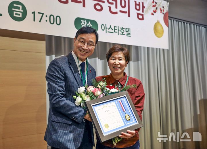 [제주=뉴시스] (오른쪽)이경미 함께하는그날협동조합 대표가 19일 제주 아스타호텔에서 열린 제주마을기업협회 송년의 밤 행사에서 표창을 받고 위성곤 국회 기후위기특별위원회 위원장과 기념 사진을 찍고 있다. (사진=함께하는그날협동조합 제공) 2025.12.22. photo@newsis.com