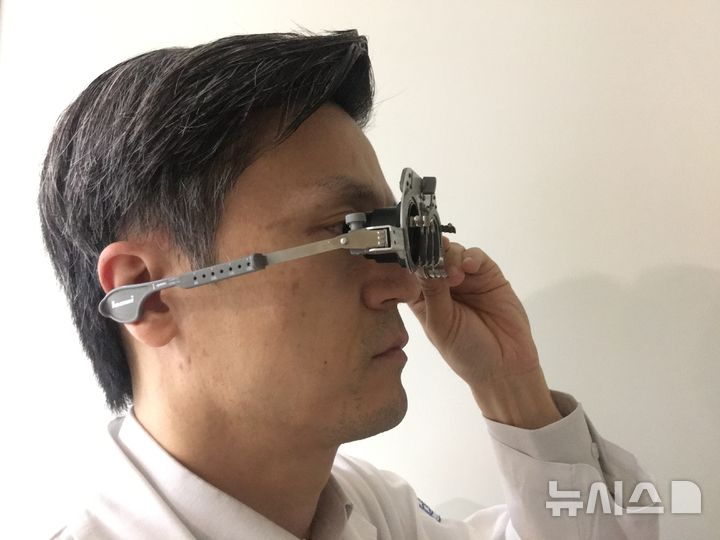 [서울=뉴시스] 황호식 가톨릭대학교 여의도성모 안과병원 교수가 본인이 직접 개발한 다초점인공수정체 체험장비를 착용하고 있다. (사진= 여의도성모병원 제공)