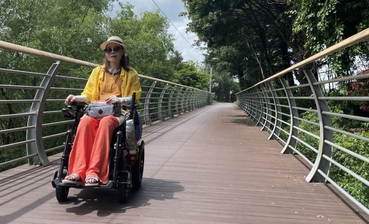 [수원=뉴시스] 성남특공대 소속 한인화(62)씨가 전동휠체어를 타고 보행 환경 점검 활동을 하고 있다. 한 씨는 1999년 사고로 장애 판정을 받은 뒤 29년째 휠체어와 동행하며 지역사회 환경 개선에 힘쓰고 있다. (사진=성남시한마음복지관 제공) 2025.12.22. photo@newsis.com *재판매 및 DB 금지