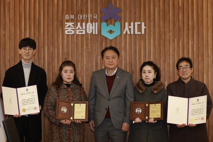 [청주=뉴시스] 김영환 충북지사가 22일 청주시 상당구 문화동 충북도청 여는마당에서 올해의 공예명인, 우수공예인에게 지정패와 증서를 전달하고 기념촬영하고 있다. (왼쪽부터) 김상문·양혜영씨, 김 지사, 문정현·최유신씨. (사진=충북도 제공) 2025.12.22. photo@newsis.com *재판매 및 DB 금지