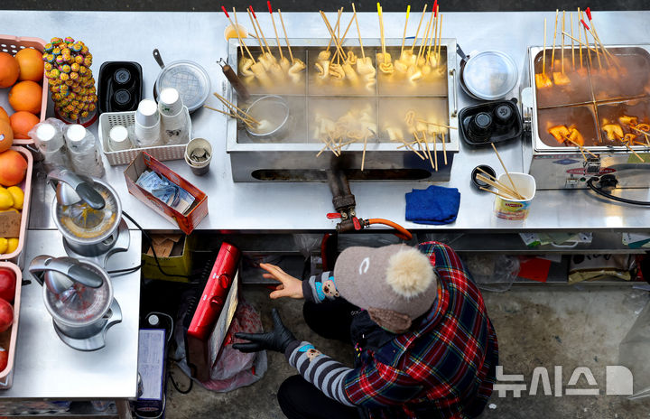 [대구=뉴시스] 이무열 기자 = 찬 공기 유입으로 기온이 크게 떨어진 22일 대구 중구 서문시장에서 한 상인이 난로에 손을 녹이고 있다. 2025.12.22. lmy@newsis.com