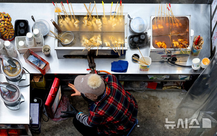 [대구=뉴시스] 이무열 기자 = 찬 공기 유입으로 기온이 크게 떨어진 22일 대구 중구 서문시장에서 한 상인이 난로에 손을 녹이고 있다. 2025.12.22. lmy@newsis.com