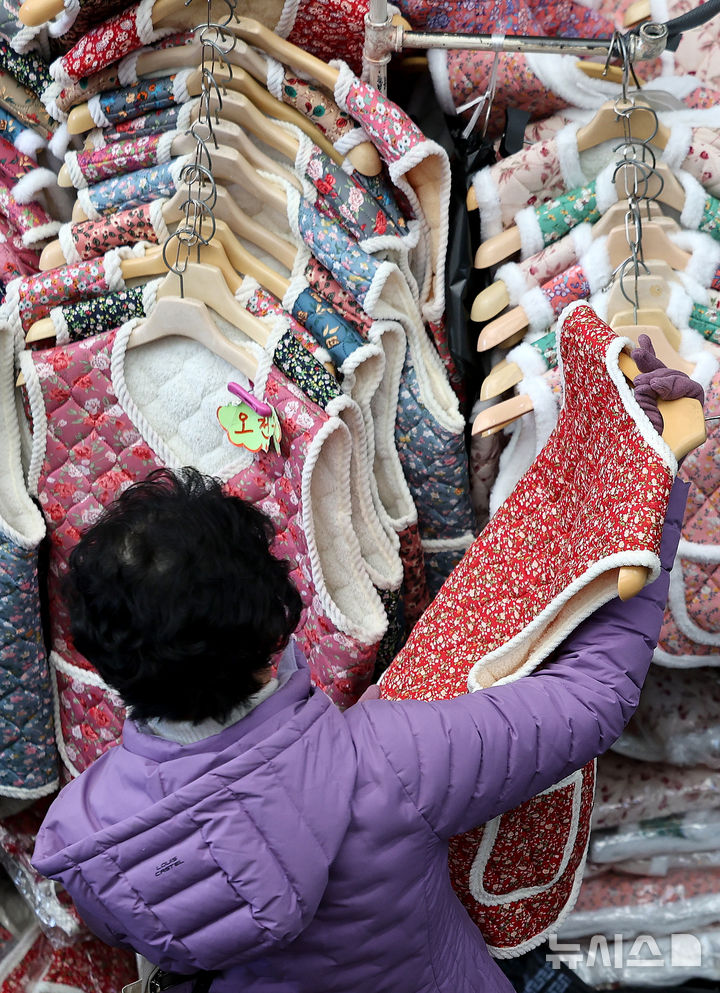 [대구=뉴시스] 이무열 기자 = 찬 공기 유입으로 기온이 크게 떨어진 22일 대구 중구 서문시장에서 한 시민이 두터운 조끼를 고르고 있다. 2025.12.22. lmy@newsis.com