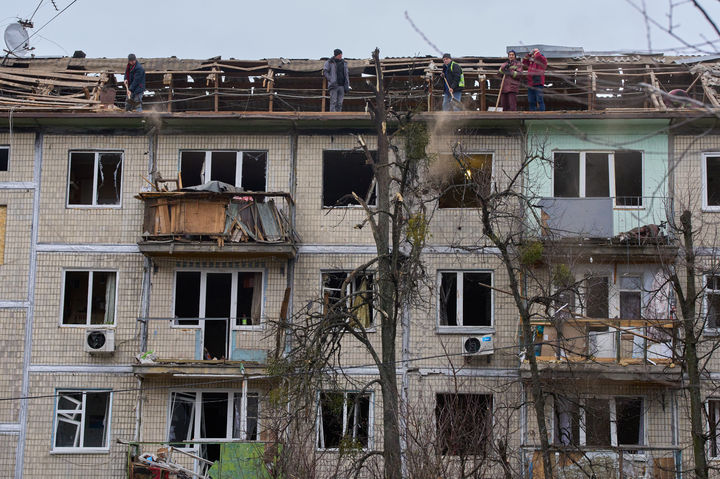 [키이우=AP/뉴시스] 지난 23일(현지 시간) 우크라이나 키이우에서 시청 소속 작업자들이 러시아의 드론 공습을 받은 아파트 건물을 정비하고 있다. 2025.12.27.