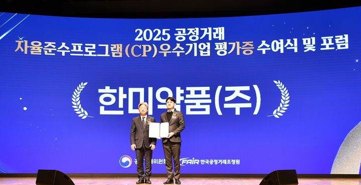 [서울=뉴시스] 한미약품 컴플라이언스팀 유승현 이사(오른쪽)가 남동일 공정거래위원회 부위원장으로부터 CP 평가증을 받은 후 기념촬영을 하고 있다. (사진=한미약품 제공) 2025.12.23. photo@newsis.com *재판매 및 DB 금지