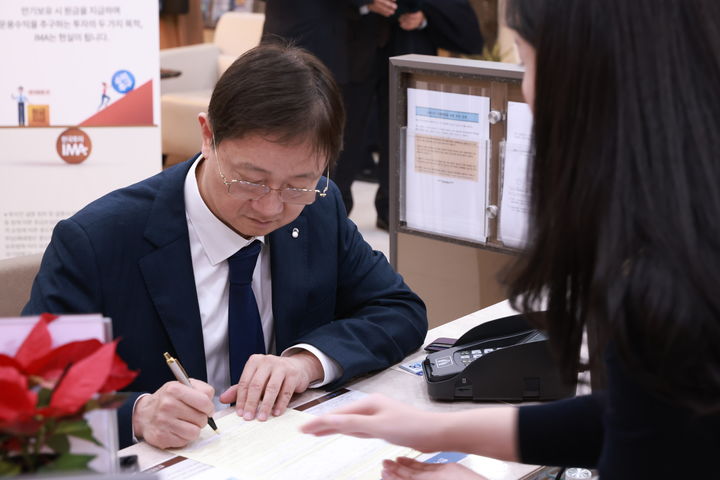 [서울=뉴시스] 이찬진 금융감독원장이 23일 한국투자증권에 방문해 IMA 1호 상품에 가입했다. (사진=금융감독원 제공) 2025.12.23. *재판매 및 DB 금지