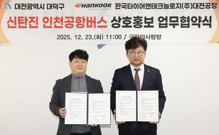 [대전=뉴시스] 조명휘 기자 = 최충규(오른쪽) 대전 대덕구청장과 황금강 한국타이어 대전공장 부공장장이 23일 구청 구민의사랑방에서 신탄진 인천공항버스 상호홍보 업무협약식을 마친 뒤 기념촬영을 하고 있다. (사진= 대덕구 제공) 2025.12.23. photo@newsis.com *재판매 및 DB 금지