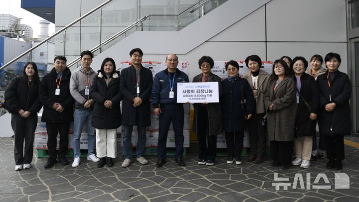 [창원=뉴시스] 23일 DN솔루션즈 창원 본사 복지관에서 신승렬(왼쪽 여섯번째) 상무가 경남지역 10개 지역아동센터 관계자들에게 사랑의 김장김치를 전달하고 있다. (사진=DN솔루션즈 제공) 2025.12.23. photo@newsis.com