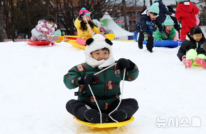 [서울=뉴시스] 김혜진 기자 = 23일 서울 노원구 서울과학기술대학교 종합운동장에 마련된 '2025 노원 씽씽 눈썰매장'에서 인근 어린이집 아이들이 눈썰매를 타며 즐거운 시간을 보내고 있다. 2025.12.23. jini@newsis.com