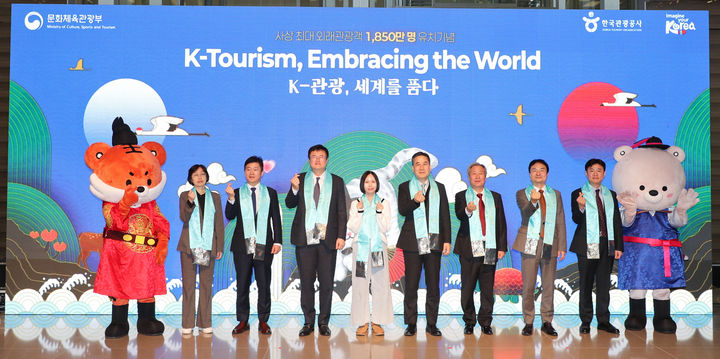 [서울=뉴시스] 김대현 문화체육관광부 제2차관이 23일 인천국제공항 제2터미널에서 열린 사상 최대 외래관광객 유치 기념행사에서 1850만번째 관광객인 싱가포르인 샬메인 리 씨 등과 기념촬영을 하고 있다. (사진=문화체육관광부 제공) 2025.12.23. photo@newsis.com *재판매 및 DB 금지