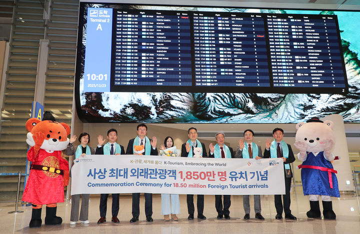 [서울=뉴시스] 김대현 문화체육관광부 제2차관이 23일 인천국제공항 제2터미널에서 열린 사상 최대 외래관광객 유치 기념행사에서 1850만번째 관광객인 싱가포르인 샬메인 리 씨 등과 기념촬영 하고 있다. (사진=문화체육관광부 제공) 2025.12.23. photo@newsis.com *재판매 및 DB 금지