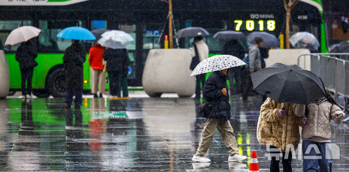 [서울=뉴시스] 정병혁 기자 = 우박과 비가 내린 23일 서울 종로구 광화문광장에서 우산을 쓴 시민들이 이동하고 있다. 2025.12.23. jhope@newsis.com