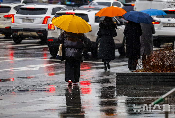 [서울=뉴시스] 정병혁 기자 = 우박과 비가 내린 23일 서울 종로구 광화문광장에서 우산을 쓴 시민들이 이동하고 있다. 2025.12.23. jhope@newsis.com