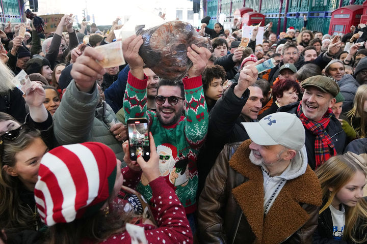 [런던=AP/뉴시스] 24일(현지 시간) 영국 런던의 스미스필드 시장에서 열린 연례 '성탄 전야 고기 경매'에서 고기 한 덩어리를 낙찰받은 한 남성이 환호하고 있다. 스미스필드 시장은 런던의 유명 고기 도매 시장 중 한 곳으로 '성탄 경매'에서는 시민들이 경매에 참여해 성탄절을 지낼 고기를 직접 구매한다. 2025.12.25.