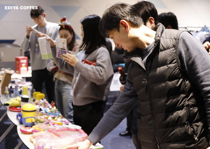 [서울=뉴시스] 지난 23일, 서울 강남구 이디야커피 사옥에서 열린 이디야 사내 플리마켓에서 임직원들이 물품을 살펴보고 있다. (사진=이디야커피 제공) 2025.12.24. photo@newsis.com *재판매 및 DB 금지