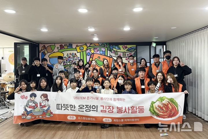 [서울=뉴시스] 지난달 30일 부산 해운대구에 위치한 희망스쿨지역아동센터에서 김장 봉사를 마친 오스템임플란트 부산생산총괄본부 임직원들이 아이들과 함께 기념촬영을 하고 있다. (사진= 오스템임플란트 제공)