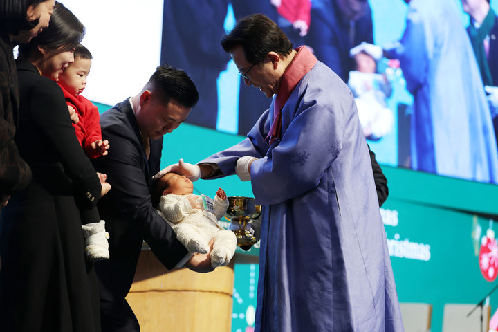 [서울=뉴시스] 25일 사랑의교회에서 진행된 '‘2025년 성탄축하 온가족연합예배'에서 아기에게 세례를 주있는 오정현 목사(오른쪽) (사잔=사랑의교회) photo@newsis.com *재판매 및 DB 금지